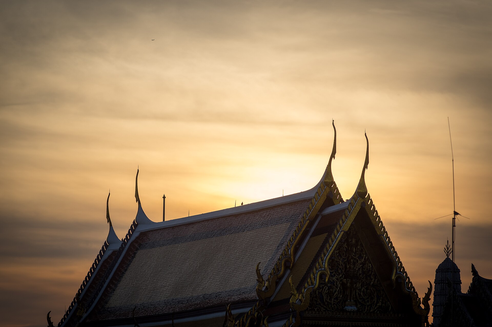 The Grand Palace in Bangkok, Thailand, with its golden spires and ornate Thai architecture against a blue sky